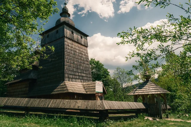 Wooden church surrounded by greenery.