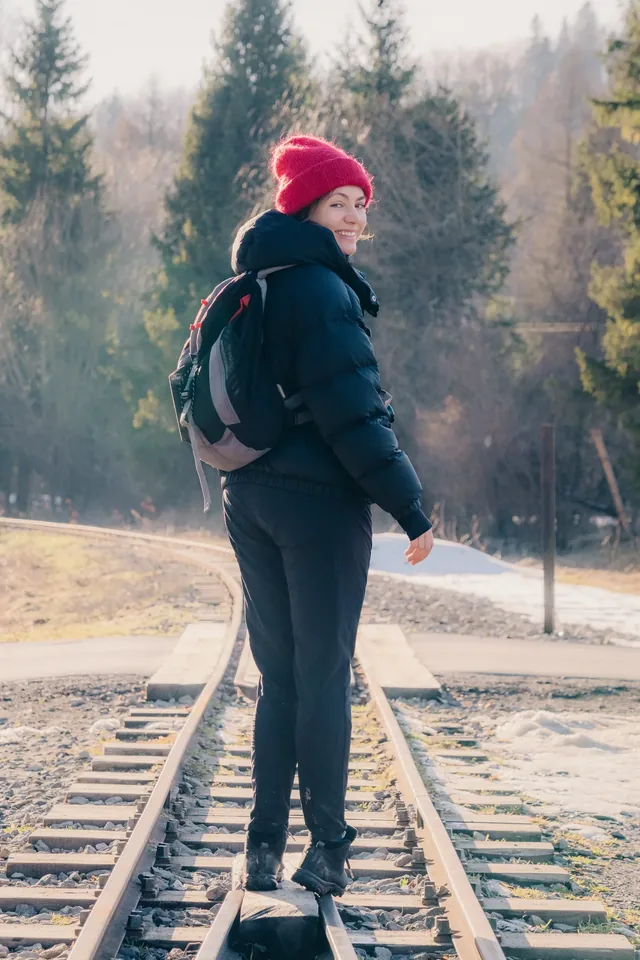 Person with a backpack on a wooden footbridge in winter.