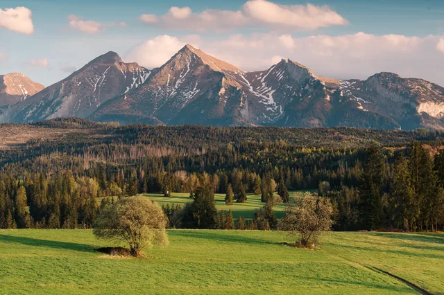 Snowy peaks above a green valley.