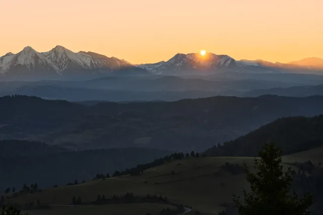 Sun at the edge of a distant mountain ridge.