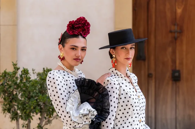 Two women in polka-dot outfits and black gloves.