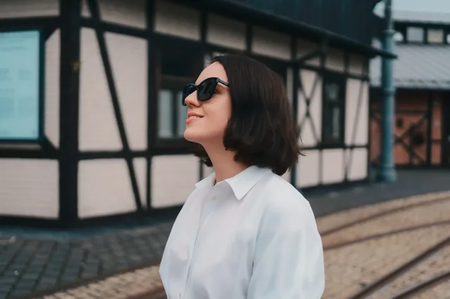 Portrait in sunglasses against a timber-framed building.