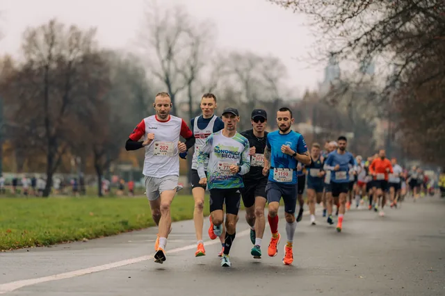 Group of runners on a paved riverside path.