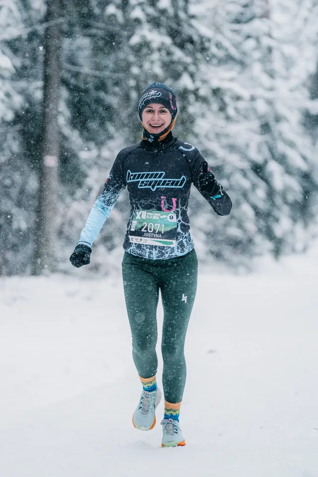 Runner in a dark shirt on a snowy path.