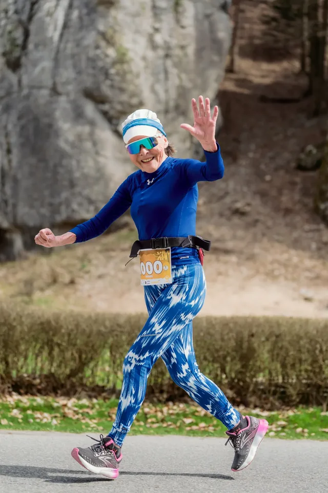 Runner in blue with a raised hand.