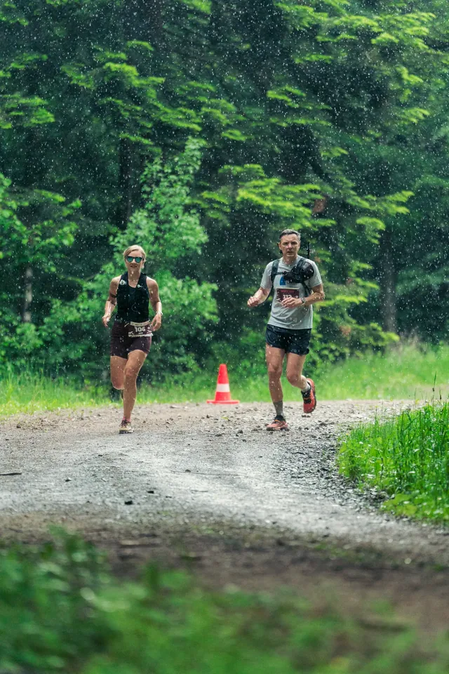 Runners on a marked bend in a forest track.